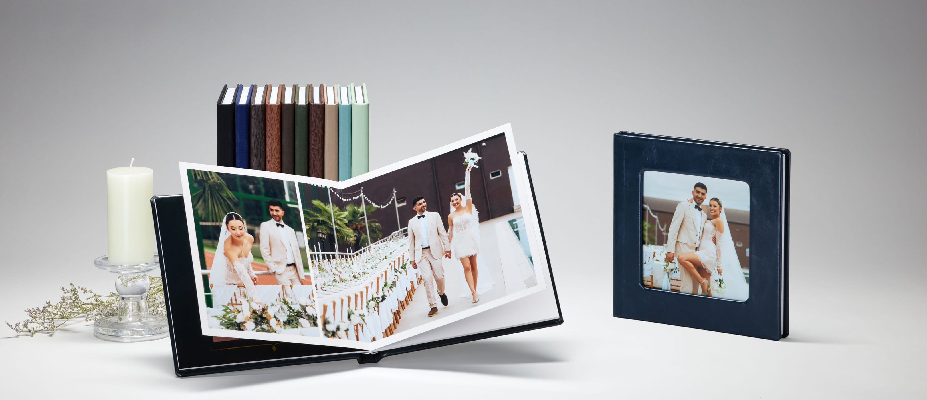 Leather layflat wedding album opened to a full-spread portrait, with cover-swatch library and framed print alongside