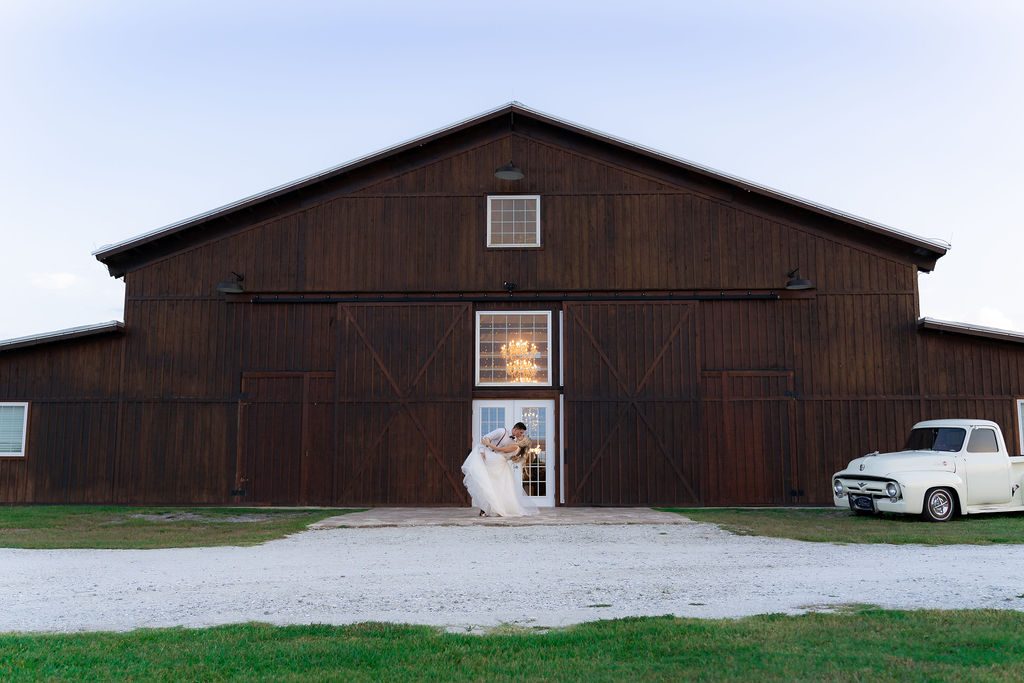 Bride and groom at a rustic barn venue captured by Precious Pics Production